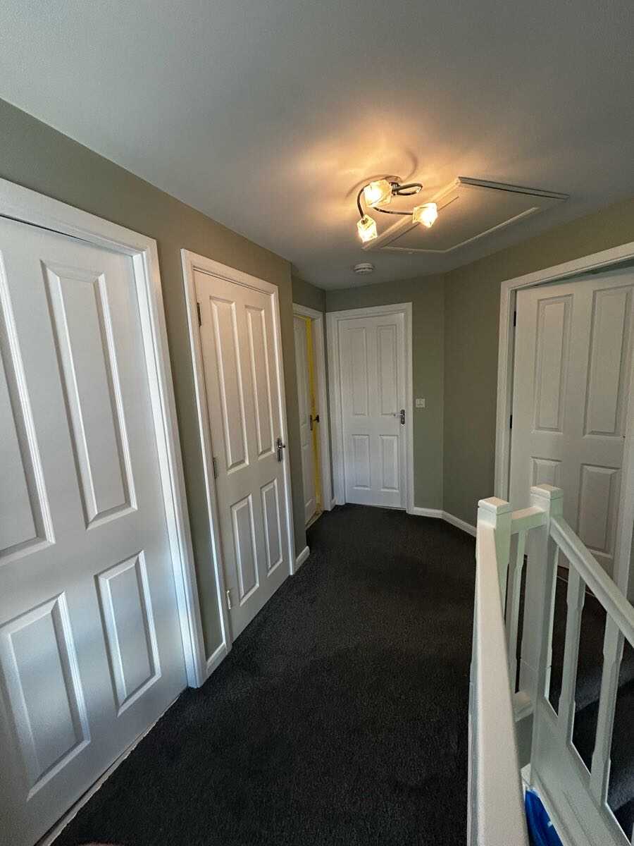 Upstairs landing with taupe painted walls and freshly painted white doors and skirting
